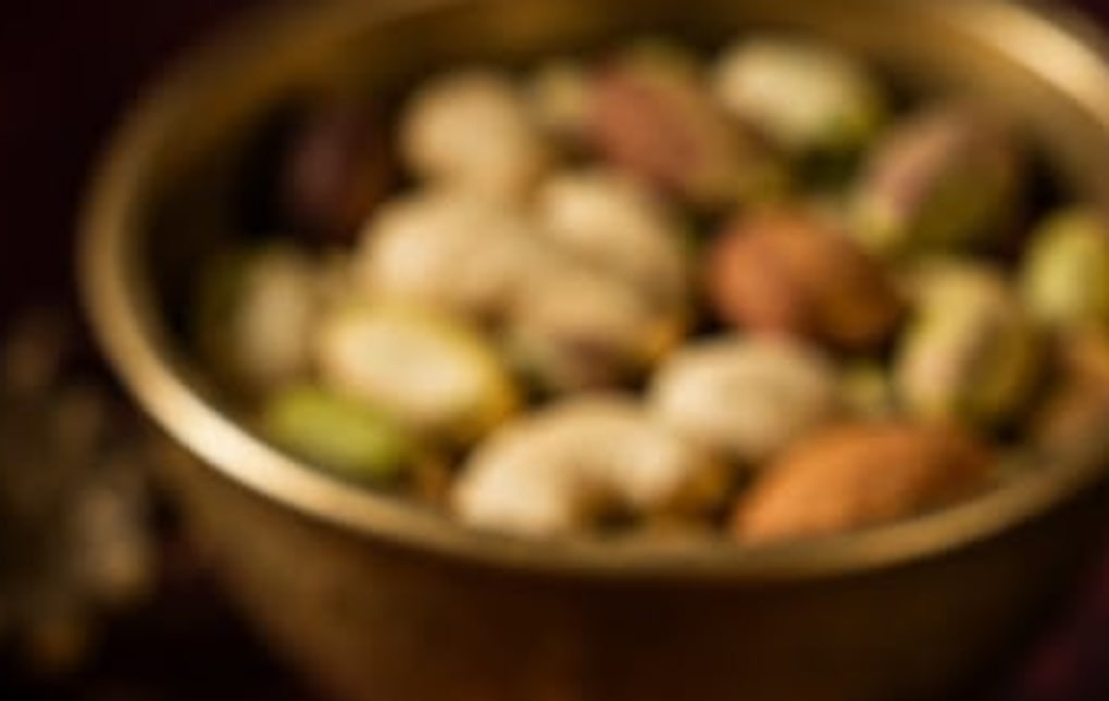 A brass bowl of pistachio, almond and cashew